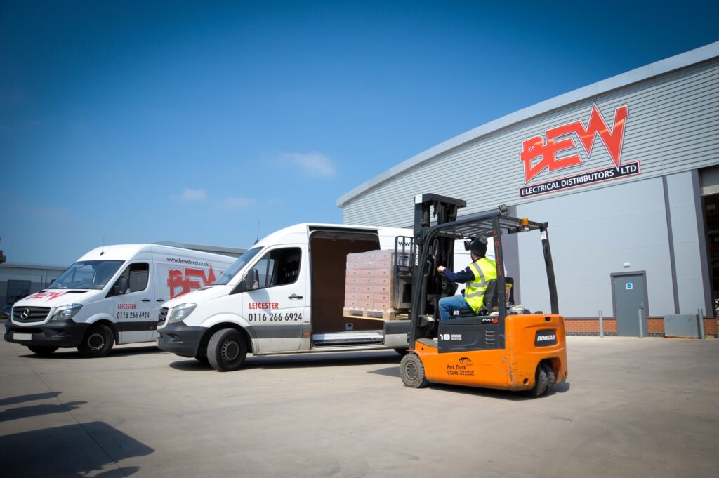 Forklift loading items into the side of BEW branded white van