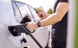 A man charging his electric car with an EV charger 